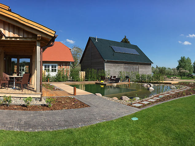 private Schwimmteichanlage mit 40 m² großem Becken, Holzterrasse und Badedeck