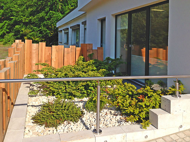 immergrüne Hochbeet-Bepflanzung mit bizarr wachsenden Nadelgehölzen